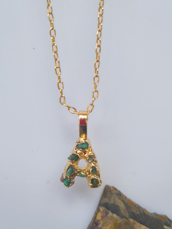 Dije Inicial Esmeralda – Cobre con oro laminado y esmeraldas naturales en bruto